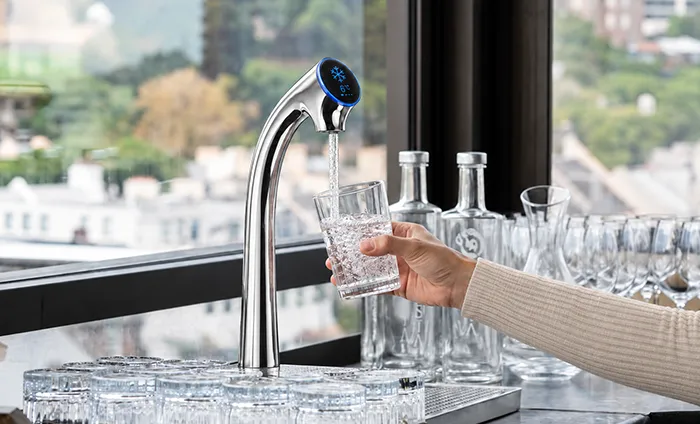Commercial sparkling water tap dispensing water into a glass